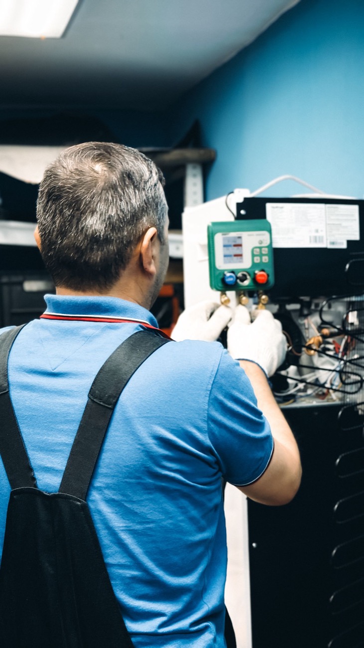 Technicien vérifiant la pression aux manomètres d'une installation de chauffage