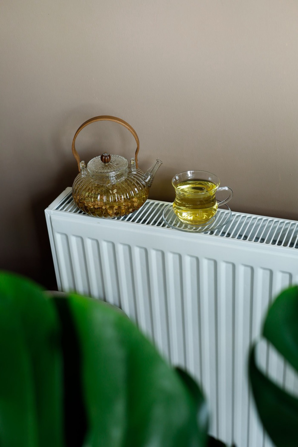 Radiateur à eau blanc avec théière posée dessus dans un intérieur lumineux